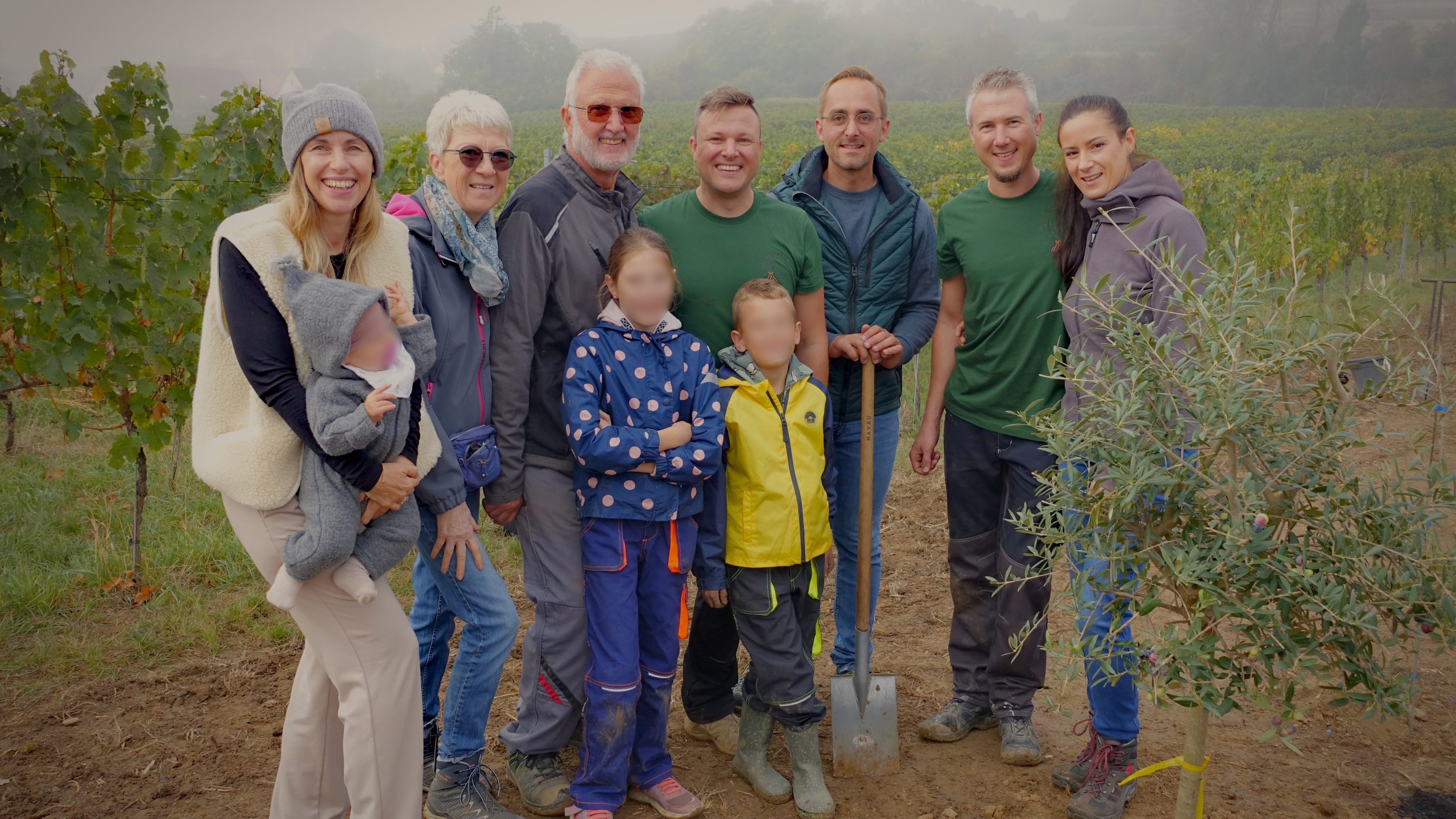 Die Familie Breier mit weiteren Beteiligten auf der Pflanzfläche am Kaiserstuhl. Die Gesichter der Kinder sind unkenntlich gemacht.
